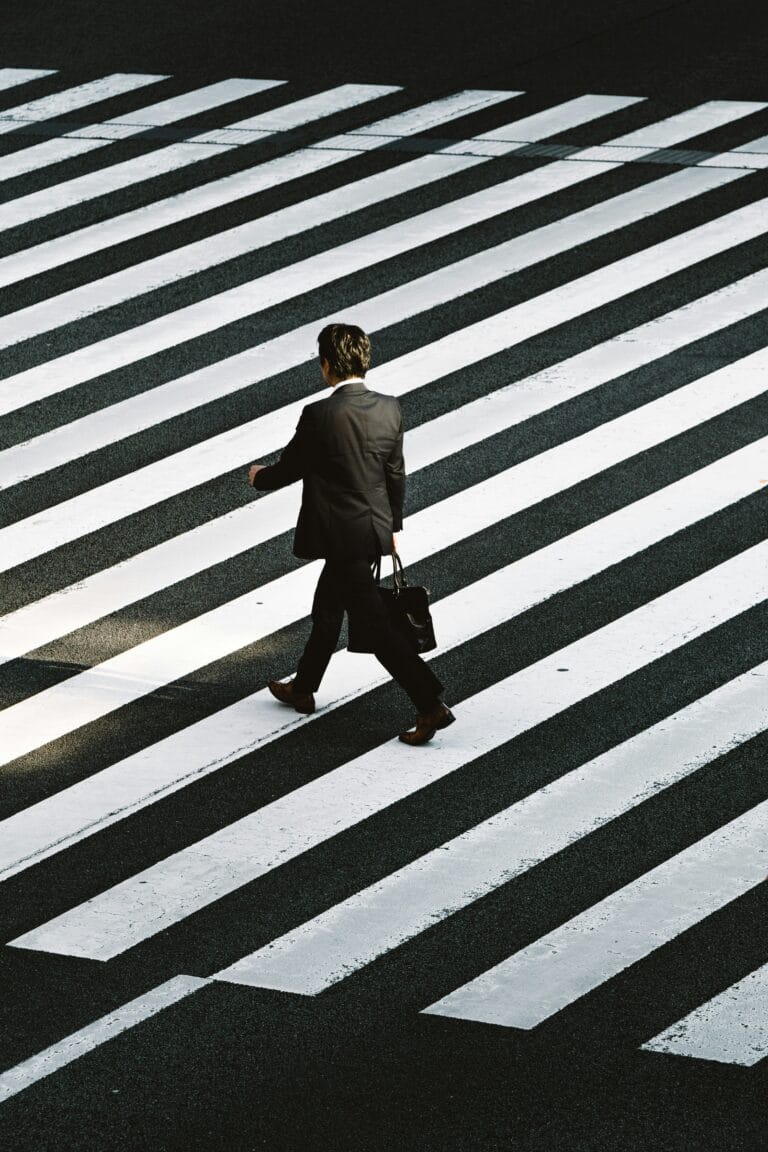 Le radici della straight photography: ideologia, contesto e precisione americana 1 man in black formal suit jacket and pants carrying black bag while walking on pedestrian lane during daytime stockpack unsplash