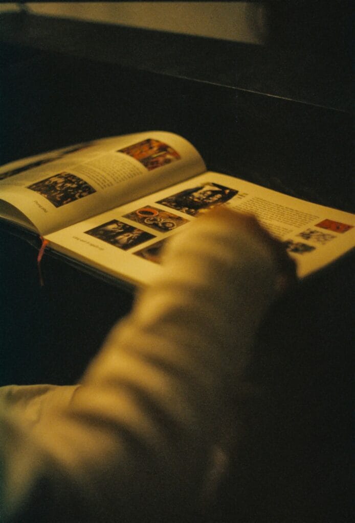 Imparare a fotografare è relativamente semplice. Imparare a vedere è un'altra cosa: richiede tempo, letture, frequentazione dei maestri e soprattutto la capacità di interrogare le immagini con la stessa serietà con cui un critico letterario interroga un testo. Dai sessanta libri fondamentali della cultura fotografica alle analisi ravvicinate degli scatti che hanno cambiato la storia — il momento decisivo di Cartier-Bresson alla Gare Saint-Lazare, il taglio perfetto del Bacio di Doisneau, l'Uomo che cade di Richard Drew, la copertina di Abbey Road — questa guida alla formazione fotografica profonda vuole costruire lo sguardo critico che separa il fotografo che scatta dal fotografo che pensa.Costruire una biblioteca fotografica: dai sessanta classici ai maestri per genere
La prima domanda che ogni fotografo serio si pone, prima o poi, è questa: cosa leggere? La risposta è più complicata di quanto sembri, perché la letteratura fotografica è vastissima, diseguale nella qualità e spesso scritta in una lingua, l'inglese, che non è quella di tutti. Esistono manuali tecnici, monografie d'autore, testi di storia e teoria, raccolte di portfolio, diari di lavoro, interviste. Esistono libri che insegnano la composizione e libri che analizzano il significato politico delle immagini. Esistono cataloghi di mostre che sono capolavori editoriali e testi accademici di quasi illeggibile densità. Navigare in questo oceano senza una bussola è difficile, e la conseguenza più frequente è che molti fotografi rinunciano alla lettura sistematica e si limitano a sfogliare Instagram, che è l'equivalente fotografico di nutrirsi solo di fast food. La formazione fotografica seria richiede invece una dieta più varia e più sostanziosa, costruita con pazienza e con una logica di progressione che va dal generale al particolare, dalla storia alla teoria, dall'analisi delle immagini altrui alla comprensione del proprio modo di guardare.
Il punto di partenza ideale per chiunque voglia costruire una biblioteca fotografica degna di questo nome è la selezione dei sessanta libri di fotografia che ogni appassionato dovrebbe conoscere e leggere. Una lista di sessanta titoli potrebbe sembrare eccessiva per chi si avvicina alla fotografia come hobby, ma in realtà rappresenta appena la superficie di una letteratura enorme: sono i sessanta libri che non si possono non avere letto se si vuole parlare di fotografia con qualche competenza. Tra questi ci sono testi di storia come quella di Beaumont Newhall, la prima grande sintesi storica della fotografia, e quella di Naomi Rosenblum, più ampia e aggiornata. Ci sono i classici della teoria visiva come Camera Lucida di Roland Barthes, che in poche pagine dense ha cambiato il modo in cui si pensa alla fotografia in relazione alla morte e alla memoria, e On Photography di Susan Sontag, che rimane a distanza di decenni il saggio critico sulla fotografia più letto e più discusso al mondo. Ci sono le monografie degli autori imprescindibili — Cartier-Bresson, Arbus, Frank, Winogrand, Salgado — e i portfolios che hanno definito i generi fotografici principali. Leggere questi sessanta libri nell'arco di qualche anno non è un esercizio accademico: è il modo più efficace per acquisire quel background culturale che permette di vedere le proprie fotografie in relazione a una tradizione, e di capire dove ci si colloca nel grande fiume della storia dell'immagine fotografica.
Ma i libri non bastano senza la conoscenza diretta dei maestri della fotografia, quei fotografi che hanno definito i linguaggi visivi che ancora oggi usiamo, spesso senza saperlo. Conoscere i maestri non significa ammirare le loro fotografie in modo generico: significa studiare le loro scelte compositive, capire i loro sistemi di lavoro, leggere le loro dichiarazioni di poetica, confrontare le serie complete piuttosto che le singole immagini famose. Un maestro come Dorothea Lange non si capisce guardando solo la Madre Migrante del 1936 — che è l'immagine per cui è nota al grande pubblico — ma studiando l'intero corpus del suo lavoro per la Farm Security Administration e i suoi scritti sul rapporto tra documentazione sociale e arte fotografica. Un maestro come Garry Winogrand non si capisce guardando le sue fotografie più citate, ma leggendo le sue interviste dove spiega che fotografava non per documentare il mondo ma per vedere come il mondo appariva nell'atto di essere fotografato: una distinzione sottile ma fondamentale per capire la sua estetica del caso controllato. Approfondire i maestri della fotografia significa imparare che dietro ogni grande immagine c'è una visione filosofica del rapporto tra chi guarda, chi è guardato e lo strumento che media questo sguardo.
Per chi preferisce organizzare lo studio per genere fotografico piuttosto che per autore, la guida ai maestri della fotografia per genere fotografico offre un percorso alternativo ma complementare. Ogni genere — ritratto, paesaggio, street photography, documentario, moda, architettura, fotografia scientifica — ha i propri maestri di riferimento, i propri canoni estetici, le proprie tradizioni tecniche e le proprie questioni etiche specifiche. Studiare i maestri del ritratto significa confrontarsi con domande che non si pongono al paesaggista: il rapporto di potere tra fotografo e soggetto, il consenso all'immagine, la responsabilità della rappresentazione di persone reali in contesti privati o pubblici. Studiare i maestri del documentario significa confrontarsi con la questione della veridicità dell'immagine fotografica e con il confine sempre più labile tra documentazione e costruzione. Organizzare la propria formazione fotografica per generi permette di approfondire le questioni specifiche che ciascun tipo di fotografia pone, senza disperdere le energie in una genericità che non porta da nessuna parte. Il consiglio è di scegliere il genere che si pratica, studiarlo a fondo attraverso i suoi maestri, e poi allargarsi ai generi adiacenti con la consapevolezza di chi sa già dove sta andando.
La formazione fotografica non si consuma solo nelle biblioteche e nei musei: passa anche attraverso il confronto diretto con chi ha più esperienza. Il format dell'esperto di fotografia che risponde offre esattamente questo: la possibilità di sottoporre domande specifiche a fotografi esperti e di ricevere risposte che tengono conto del contesto e della situazione concreta di chi chiede. Questo tipo di apprendimento dialogico, che la scuola tradizionale tende a marginalizzare a favore della lezione frontale, è in realtà quello più efficace per la fotografia: i problemi reali che un fotografo incontra sul campo raramente sono quelli descritti nei manuali, e la capacità di adattare i principi generali alle situazioni specifiche è una competenza che si acquisisce attraverso la pratica e il confronto, non attraverso la sola lettura. La storia della Royal Photographic Society, fondata a Londra nel 1853 e tuttora una delle istituzioni fotografiche più autorevoli al mondo, è la storia di un'organizzazione che ha sempre messo al centro proprio questo tipo di apprendimento comunitario e dialettico: l'incontro tra fotografi di diversa esperienza, la discussione delle immagini, la critica costruttiva come strumento di crescita collettiva. La Royal Photographic Society fu la prima istituzione a istituire premi e riconoscimenti fotografici su base qualitativa, contribuendo a definire i canoni estetici che ancora oggi, in modo più o meno consapevole, influenzano il giudizio sulla fotografia di qualità.
Leggere i maestri: da Ansel Adams ad August Sander, dalla composizione alla politica dell'immagine
C'è un modo superficiale di studiare i grandi fotografi e un modo profondo. Il modo superficiale è guardare le loro immagini più note, leggere la biografia in due paragrafi e passare avanti. Il modo profondo è chiedersi cosa c'è dentro quelle immagini, quali scelte le hanno prodotte, cosa raccontano del loro tempo e del loro autore, cosa nascondono sotto la superficie visibile. La analisi fotografica profonda non è un esercizio riservato ai critici accademici: è una competenza che ogni fotografo serio dovrebbe coltivare, perché capire perché una fotografia funziona è il modo più efficace per capire come farne funzionare una propria. I due maestri che prendiamo in esame in questo capitolo — Ansel Adams e August Sander — sono apparentemente distantissimi per soggetto, estetica e funzione sociale della loro fotografia, eppure condividono una caratteristica fondamentale: ogni loro immagine è il risultato di un sistema di pensiero preciso e coerente, applicato con ostinazione per decenni.
Ansel Adams è il fotografo di paesaggio più famoso della storia, ma ridurlo a questo sarebbe un errore di prospettiva. Adams era soprattutto un teorico della composizione fotografica, uno studioso del rapporto tra luce e forma, un costruttore di sistemi. Il suo Sistema Zonale, che divide la scala tonale in undici zone dal nero assoluto al bianco puro e che permette al fotografo di controllare con precisione matematica l'esposizione e lo sviluppo per ottenere il risultato desiderato, è ancora oggi il sistema di riferimento per chiunque lavori con la pellicola in bianco e nero. Ma al di là della tecnica, ciò che rende Adams un maestro da studiare è la sua capacità di trasformare le regole compositive in strumenti di visione: le regole compositive di Ansel Adams applicate alla fotografia di paesaggio non sono prescrizioni rigide ma principi di organizzazione dello spazio visivo che possono essere applicati, con gli opportuni adattamenti, anche alla fotografia digitale e persino alla fotografia con lo smartphone. La lezione di Adams è che la composizione non è un ornamento dell'immagine ma la sua struttura portante: cambiare la composizione di una fotografia significa cambiare il suo significato, non solo la sua estetica. Chi studia Adams con attenzione impara a guardare il mondo in termini di masse tonali, di linee di forza e di relazioni spaziali prima ancora di premere il pulsante di scatto, e questo cambia irreversibilmente il modo in cui si fotografa.
La distanza tra Adams e August Sander non potrebbe essere più grande: il primo fotografava montagne e deserti in un'America che stava costruendo la propria mitologia naturalistica, il secondo fotografava persone in una Germania che stava costruendo la propria tragedia politica. Eppure entrambi condividevano un rigore metodologico assoluto e una visione del progetto fotografico come opera di lungo respiro, non come raccolta di immagini occasionali. Il progetto di Sander, Uomini del Ventesimo Secolo, era un atlante fotografico della società tedesca del primo Novecento: ritratti di persone di ogni classe sociale, ogni professione e ogni origine, realizzati con una tecnica uniforme e un approccio sistematico che mirava a costruire un inventario visivo completo dell'umanità tedesca del suo tempo. Ma leggere i ritratti di Sander come semplice documentazione sociologica significa perderne la dimensione più interessante: quella dei messaggi politici nascosti nelle fotografie di August Sander. Sander fotografava con uno sguardo apparentemente neutro, che trattava il contadino e il banchiere con la stessa distanza formale, la stessa luce, lo stesso formato. Ma questa neutralità apparente era in realtà una scelta politica potente: in un'epoca in cui la fisiognomica pseudoscientifica pretendeva di leggere il carattere, l'intelligenza e la razza dal volto delle persone, Sander dimostrava attraverso le sue immagini che ogni classificazione gerarchica era arbitraria e che l'umanità era irriducibile a tipologie. Non è un caso che i nazisti, dopo l'ascesa al potere nel 1933, confiscassero e distruggessero le lastre di Sander: avevano capito meglio di molti critici moderni la natura eversiva di quel progetto apparentemente neutro.
Lo studio dei maestri attraverso la loro opera richiede anche la capacità di contestualizzare storicamente e socialmente il loro lavoro. La analisi fotografica di Sander non si può separare dalla storia della Repubblica di Weimar e dall'ascesa del nazismo, così come la cultura visiva di Adams non si può separare dal movimento ambientalista americano e dal ruolo del Sierra Club nella protezione dei parchi nazionali. Capire in quale contesto un'immagine è stata prodotta non significa ridurla a documento storico: significa aggiungere alla comprensione estetica una comprensione delle forze culturali e politiche che l'hanno resa possibile e necessaria. I grandi fotografi non fotografano nel vuoto: fotografano in risposta al mondo che li circonda, e le loro immagini portano sempre, in modo più o meno esplicito, i segni di questo dialogo con la realtà storica.
Un caso particolare di questo dialogo tra fotografia e potere è quello di Richard Avedon, il cui modo di fare ritratto fotografico era tutto fuorché neutro nonostante l'apparenza di semplicità formale. I ritratti di Avedon — fondo bianco, luce piatta, soggetto molto vicino alla macchina — sembrano eliminare ogni elemento di distrazione per portare all'essenziale il rapporto tra fotografo e soggetto. Ma è esattamente qui che sta la forza e la violenza latente del suo approccio: come analizza in profondità lo specchio deformante del rapporto tra fotografo e soggetto nei ritratti di Avedon, la semplicità formale di Avedon era una trappola per i soggetti, che si trovavano privati di ogni schermo protettivo — l'abbigliamento, l'ambiente, gli oggetti di scena — e costretti a confrontarsi con la macchina fotografica in modo frontale e totale. Il risultato era spesso di una crudezza psicologica che i soggetti stessi non si aspettavano: Avedon fotografava il potere — presidenti, CEO, attori famosi — con la stessa implacabilità con cui fotografava gli anziani del West americano, e in entrambi i casi il risultato era un'immagine che mostrava qualcosa che il soggetto probabilmente avrebbe preferito non mostrare. La questione del potere nel ritratto fotografico — chi ha potere su chi, chi decide come l'altro appare — è una delle più importanti della cultura visiva contemporanea, e Avedon ne è il caso di studio più istruttivo.
Anatomia di un capolavoro: il momento decisivo, il taglio perfetto e la fotografia come evento
Ci sono fotografie che si guardano e si passa avanti. E ci sono fotografie davanti alle quali ci si ferma, si torna indietro, ci si chiede come sia stato possibile. La differenza tra le une e le altre non è quasi mai nella soggettività dello spettatore: è nella struttura dell'immagine, nel modo in cui ogni suo elemento contribuisce a un insieme che funziona con una coerenza quasi impossibile da spiegare razionalmente ma reale e verificabile. L'analisi di queste fotografie — di come sono state realizzate, di cosa le rende indistruttibili nel tempo, di perché continuano a parlare a spettatori di epoche e culture diverse — è uno degli esercizi formativi più efficaci che esistano per chi vuole affinare il proprio sguardo. Non si tratta di scoprire la formula magica della fotografia perfetta, che non esiste, ma di capire quali problemi visivi queste immagini hanno risolto in modo esemplare, e di usare questa comprensione come strumento per affrontare i propri problemi visivi con maggiore consapevolezza.
La fotografia più analizzata, più citata e più imitata di tutta la storia della street photography è probabilmente quella scattata da Henri Cartier-Bresson dietro la Gare Saint-Lazare nel 1932. L'uomo che salta sopra una pozzanghera, il riflesso nell'acqua, il poster sullo sfondo che ripete la figura saltante, la perfezione geometrica dei cerchi concentrici nell'acqua e del profilo circolare che si rispecchia: tutto in questa fotografia funziona con una precisione che sembra impossibile per uno scatto rubato, non costruito. Cartier-Bresson teorizzò il concetto di momento decisivo — l'istante in cui tutti gli elementi visivi si allineano in modo perfetto — e questa fotografia è la sua dimostrazione più completa. Ma studiare la Gare Saint-Lazare significa anche capire ciò che l'analisi superficiale tende a dimenticare: Cartier-Bresson non aspettava passivamente che il momento decisivo accadesse. Frequentava luoghi, tornava più volte, studiava le geometrie preesistenti dello spazio e aspettava che un soggetto vi si inserisse nel modo giusto. Il momento decisivo era il risultato di una preparazione metodica, non di una fortuna casuale. Questa distinzione è fondamentale per la formazione fotografica: il caso nella fotografia esiste, ma i fotografi che lo sfruttano al meglio sono quelli che si sono preparati a riconoscerlo quando arriva.
Altrettanto illuminante, per ragioni diverse, è lo studio del Bacio di Robert Doisneau e in particolare della questione che raramente viene affrontata: perché il taglio originale è perfetto e le varianti no. L'analisi di perché un centimetro può cambiare la storia: il taglio originale del Bacio di Doisneau e perché è perfetto porta direttamente al cuore del problema compositivo: la differenza tra un'immagine che funziona e una che quasi funziona è spesso di dimensioni millimetriche, di rapporti proporzionali che all'occhio conscio sembrano equivalenti ma che all'occhio inconscio producono sensazioni radicalmente diverse. Il Bacio di Doisneau — scattato nel 1950 davanti all'Hôtel de Ville di Parigi e diventato una delle immagini più riprodotte del Novecento — ha nel suo taglio originale un equilibrio tra la coppia che si bacia, il passante sullo sfondo e il bordo dell'inquadratura che non è replicabile spostando di qualche centimetro il bordo dell'immagine senza perdere qualcosa di essenziale. Studiare perché questo accade significa sviluppare quella sensibilità ai rapporti proporzionali interni all'immagine che è la componente più difficile da insegnare e più difficile da acquisire della cultura visiva: non si impara leggendo, si impara guardando migliaia di immagini con attenzione critica e confrontando quelle che funzionano con quelle che quasi funzionano.
Non tutte le fotografie iconiche sono nate dalla ricerca estetica. Alcune sono diventate icone malgrado se stesse, perché il momento storico che documentavano era di una tale potenza che qualsiasi immagine avrebbe acquisito un peso insopportabile. L'Uomo che cade del 2001 di Richard Drew appartiene a questa categoria: scattata l'11 settembre 2001 durante il crollo delle Torri Gemelle, ritrae una persona che cade nel vuoto dalla Torre Nord. Questa fotografia pone alla analisi fotografica domande di un tipo completamente diverso rispetto a quelle che pone Cartier-Bresson o Doisneau: non domande di composizione o di momento decisivo, ma domande etiche sulla responsabilità del fotografo che documenta una morte, sul diritto alla privacy del soggetto in un momento di estrema vulnerabilità, sul rapporto tra il dovere di documentare la storia e il rispetto per la dignità umana. L'immagine di Drew fu pubblicata da molti giornali il giorno dopo gli attentati e poi ritirata dalla circolazione sotto la pressione dell'opinione pubblica americana, che la trovava irrespettosa verso le vittime. Il dibattito che ne seguì — sull'etica del fotogiornalismo, sui limiti della rappresentazione della morte, sul ruolo delle immagini nel lutto collettivo — è uno dei più importanti della storia della cultura visiva contemporanea, e non si può affrontare seriamente la fotografia documentaria senza aver riflettuto a fondo su questa immagine e sulle questioni che solleva.
Un'ultima analisi d'autore che merita attenzione in questo contesto è quella relativa alla copertina di Abbey Road dei Beatles, fotografata da Iain Macmillan nel 1969. Si potrebbe pensare che una copertina discografica sia un territorio marginale per una discussione sulla formazione fotografica seria, ma questa fotografia è in realtà uno dei casi di studio più istruttivi sulla semplicità come scelta coraggiosa. Macmillan aveva a disposizione dieci minuti di riprese sulla zebra davanti agli studi di Abbey Road a Londra, sei lastre e un concetto essenziale: i quattro Beatles che camminano in fila. Nessuno sfondo artificiale, nessuna elaborazione, nessun simbolismo esplicito — solo quattro persone che attraversano una strada nel modo più naturale possibile. Eppure la fotografia risultante ha una forza visiva e una capacità di evocare un'epoca che poche immagini della storia del rock hanno raggiunto. La lezione è quella della sottrazione: togliere elementi, semplificare l'inquadratura, eliminare tutto ciò che non è strettamente necessario porta spesso risultati più potenti dell'accumulo di significati e simboli. È una lezione che vale nella fotografia di moda, nel ritratto, nel reportage e in qualsiasi altro genere: la semplicità non è povertà di idee, è chiarezza di visione.
Costruire uno sguardo critico: dalla teoria alla pratica quotidiana della formazione visiva
La formazione fotografica non è un processo con una fine definita. Non esiste il momento in cui si può dire di aver imparato abbastanza, di aver letto abbastanza, di aver guardato abbastanza. È invece un processo continuo, fatto di spirali che tornano sugli stessi autori e sugli stessi temi con occhi sempre diversi: le fotografie di Cartier-Bresson che si guardano a vent'anni sembrano completamente diverse da quelle che si guardano a quaranta, non perché le fotografie siano cambiate, ma perché è cambiata la propria capacità di vederle. Questo è il senso profondo della cultura visiva: non un corpus di conoscenze da accumulare, ma una capacità di sguardo da affinare continuamente attraverso l'esposizione sistematica a immagini di qualità e alla riflessione critica su di esse. La buona notizia è che questa formazione non richiede frequentare un'accademia o vivere in una grande città: richiede metodo, curiosità e la disponibilità a mettere in discussione le proprie certezze ogni volta che un'immagine eccezionale le sfida.
Il metodo più efficace per sviluppare uno sguardo critico è quello che potremmo chiamare della lettura parallela: leggere la teoria e guardare le immagini contemporaneamente, verificando continuamente i concetti teorici sulle immagini concrete e usando le immagini concrete per affinare la comprensione dei concetti teorici. Leggere Barthes senza guardare fotografie è come leggere un manuale di nuoto senza toccare l'acqua: si acquisiscono concetti, ma non si sviluppa la competenza pratica che solo la frequentazione diretta del materiale può dare. Al contrario, guardare fotografie senza leggere teoria è come nuotare senza capire perché si galleggia: si può anche essere bravi, ma senza la comprensione dei principi che sottendono la propria pratica si rimane intrappolati in ciò che già si sa fare, incapaci di crescere in modo sistematico. La formazione fotografica efficace intreccia costantemente questi due livelli, usando la lettura per problematizzare l'esperienza visiva e l'esperienza visiva per dare carne ai concetti astratti della lettura.
Un secondo elemento fondamentale della formazione è la frequentazione delle istituzioni: musei, gallerie, festival fotografici, biblioteche specializzate. La Royal Photographic Society, già citata, è un esempio di istituzione che ha costruito nel tempo un sistema di premi, mostre e pubblicazioni che costituisce un archivio vivente della storia della fotografia britannica e mondiale. Ma simili istituzioni esistono in quasi tutti i paesi: il MoMA di New York con la sua collezione fotografica, il Jeu de Paume di Parigi, la Deutsche Fotothek di Dresda, il Victoria and Albert Museum di Londra, la Fotostiftung Schweiz di Winterthur. Frequentare queste istituzioni — anche solo attraverso i loro archivi digitali online — significa esporre continuamente il proprio sguardo a fotografie di qualità certificata, costruendo gradualmente quella capacità di discriminazione visiva che è alla base di qualsiasi analisi fotografica seria. La differenza tra un fotografo che ha frequentato musei e gallerie per anni e uno che non lo ha fatto non è nella tecnica: è nella ricchezza del repertorio visivo interno, in quella biblioteca mentale di immagini di riferimento che permette di riconoscere la qualità quando la si vede e di capire cosa manca quando non c'è.
Il terzo elemento, forse il più trascurato, è la scrittura. Scrivere di fotografia — anche solo per sé stessi, in un diario di lavoro o in un quaderno di appunti — costringe a chiarire i propri pensieri in modo che il solo guardare non richiede. Quando si prova a spiegare perché una fotografia funziona, ci si rende conto di quanto sia difficile articolare in parole ciò che l'occhio riconosce istintivamente, e questa difficoltà è formativa: obbliga a sviluppare un vocabolario critico, a precisare i concetti, a distinguere le sensazioni soggettive dagli elementi oggettivi dell'immagine. I grandi fotografi che hanno anche scritto — Adams con il suo sistema, Cartier-Bresson con L'istante decisivo, Arbus con le sue lettere — ci hanno lasciato non solo le immagini ma la chiave per leggere le immagini, e questa doppia testimonianza è di un valore formativo inestimabile. Imparare a scrivere di fotografie, anche in modo rudimentale e privato, è uno degli esercizi più efficaci per sviluppare quella coscienza critica del proprio lavoro che separa il fotografo riflessivo da quello puramente istintivo.
La formazione fotografica seria è, in definitiva, un'educazione dello sguardo nel senso più pieno del termine: un processo che non riguarda solo la fotografia ma il modo in cui si guarda il mondo, si interpretano le immagini, si costruisce il significato di ciò che si vede. Chi si forma seriamente come fotografo — attraverso i libri fondamentali, attraverso lo studio dei maestri per genere, attraverso l'analisi ravvicinata delle fotografie iconiche che hanno fatto la storia — acquisisce qualcosa che va ben al di là della capacità tecnica di produrre immagini tecnicamente corrette: acquisisce la capacità di vedere, che è la cosa più rara e più preziosa che un fotografo possa avere, e che nessuna macchina fotografica, nessun obiettivo e nessun software di post-produzione potrà mai sostituire.
Fonti di approfondimento
Per chi voglia costruire una formazione fotografica solida e sistematica, due risorse di riferimento internazionale sono imprescindibili:
MoMA – Photography Collection & Essays: il Museo di Arte Moderna di New York mette a disposizione online non solo la propria collezione fotografica — tra le più importanti al mondo — ma anche saggi critici, interviste ad autori e materiale didattico sulla analisi fotografica e sulla storia della cultura visiva del Novecento. È un punto di partenza gratuito e autorevole per qualsiasi percorso di formazione fotografica seria.
Royal Photographic Society – Learning Resources: la società fotografica più antica del mondo mette a disposizione dei propri soci e, parzialmente, del pubblico generale un vasto archivio di risorse formative sulla tecnica, sulla storia e sulla teoria della fotografia, con particolare attenzione al rapporto tra cultura visiva e pratica fotografica professionale. Le fellowship e le distinzioni della RPS rimangono i riconoscimenti fotografici più autorevoli nel mondo anglosassone.
