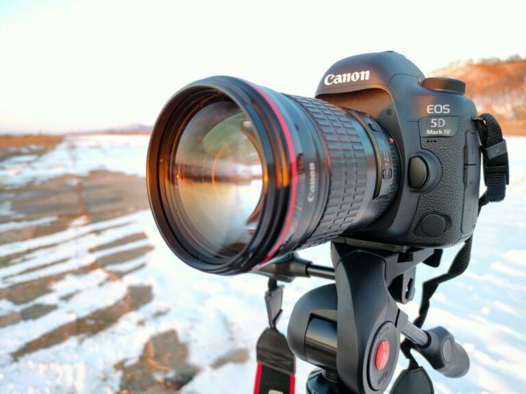 Storia della fotografia digitale 20 full frame digital camera canon 5d mark 4 with canon 135mm f2l usm lens on black tripod camera on blurry winter background stockpack unsplash